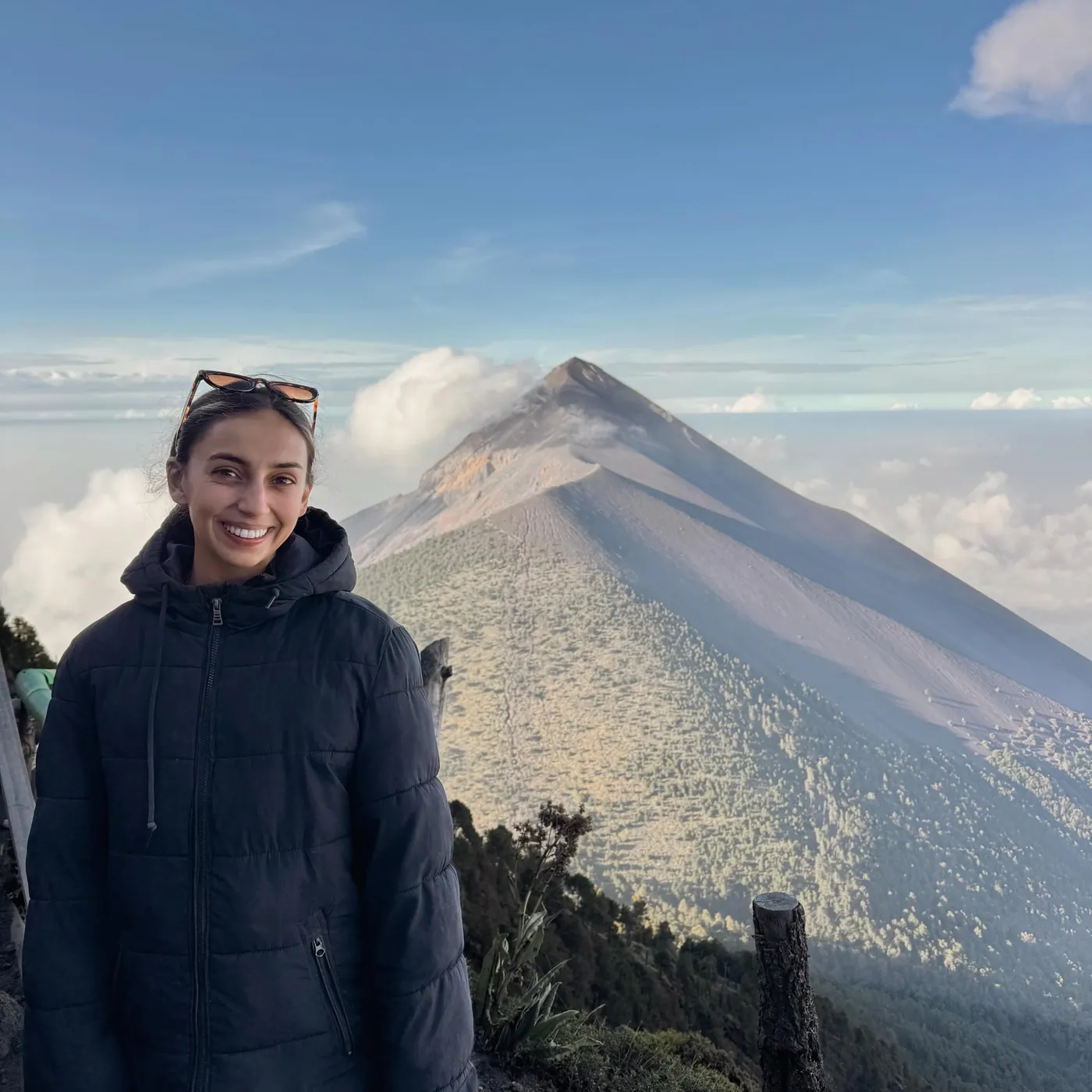 Natasha in a puffer jacket in front of the volcano