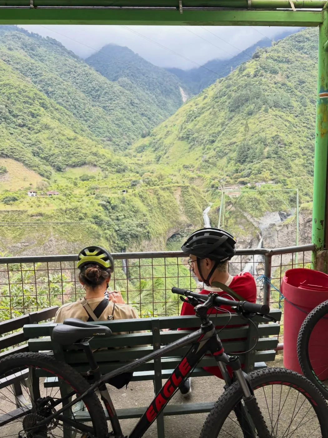 Two cyclists by a green valley