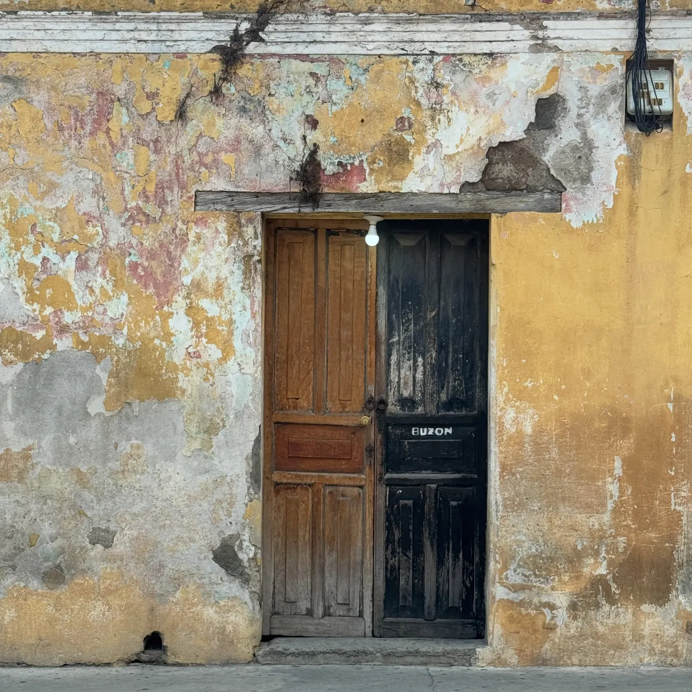 A worn yellow wall and wooden door, Antigua