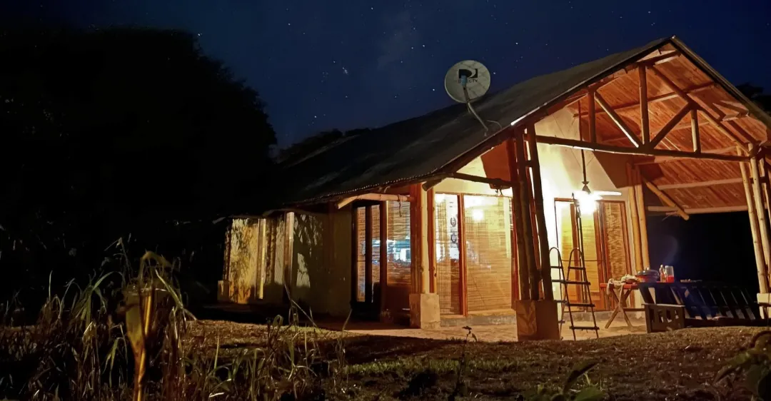 A lit wooden cabin under a night sky on Ruta 40